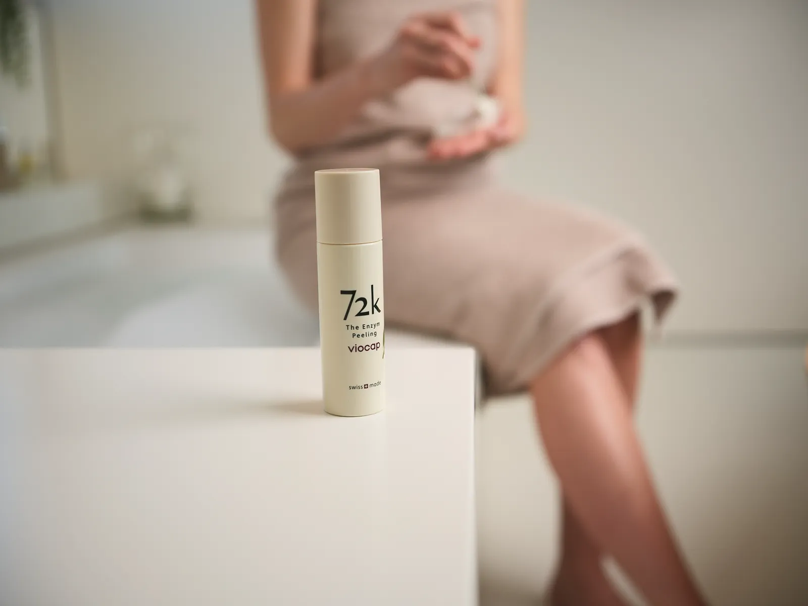 72K Enzym-Peeling auf dem Wannenrand, dahinter Model im Handtuch