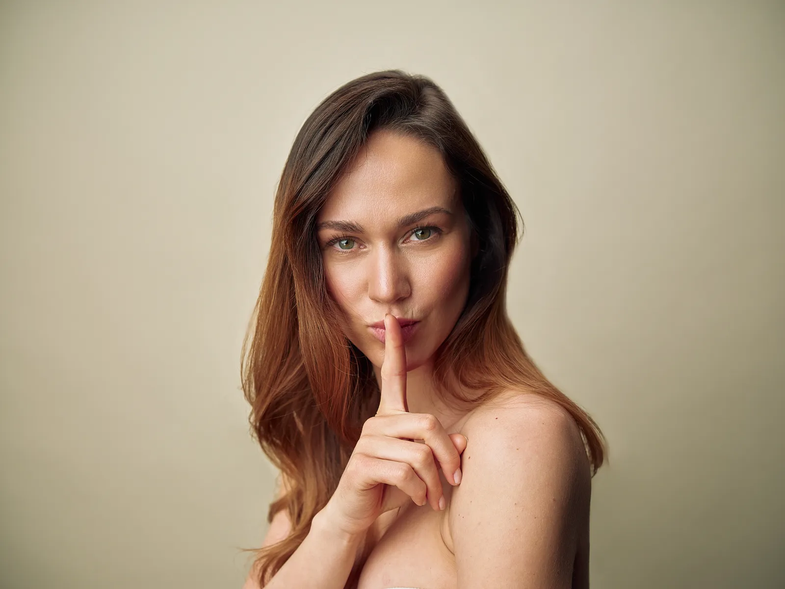 Model legt verspielt einen Finger auf die Lippen